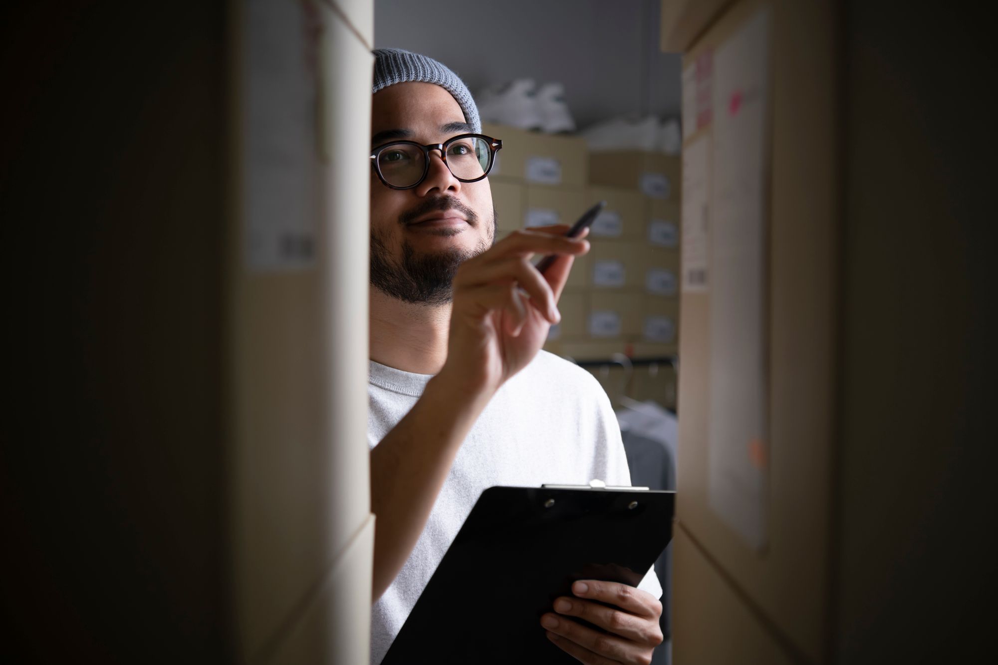 A male online shop owner counting inventory in a warehouse