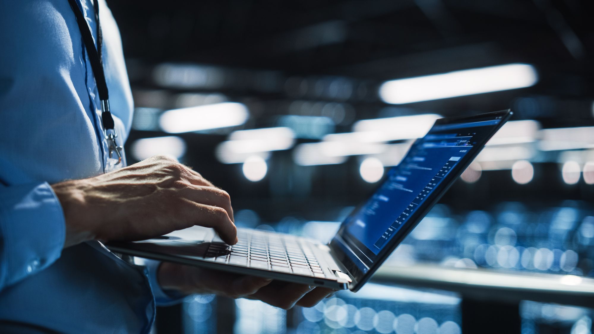 A male online shop owner calculating the reorder point for inventory on a laptop