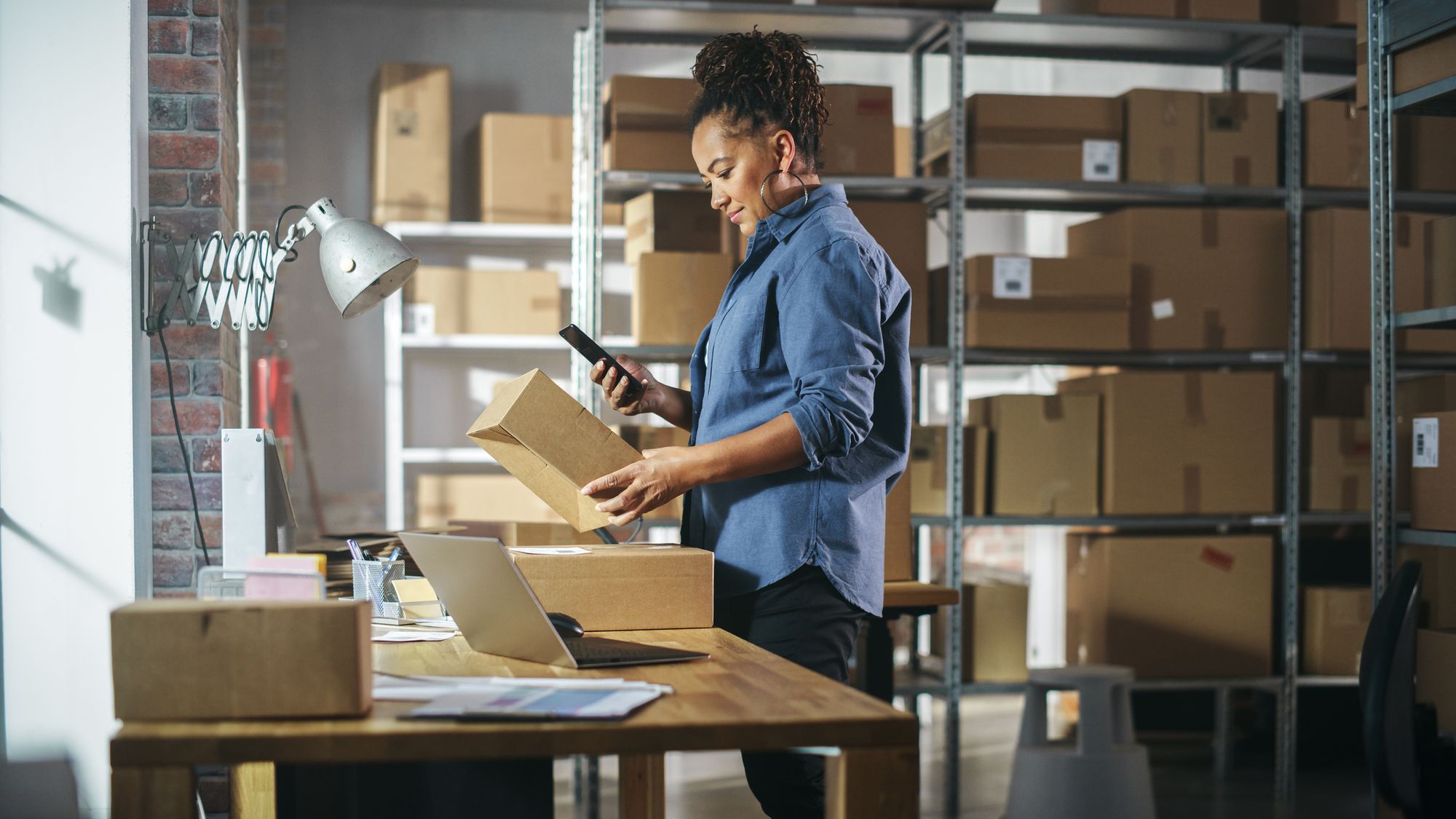 A female employee using a smartphone to record outbound stock