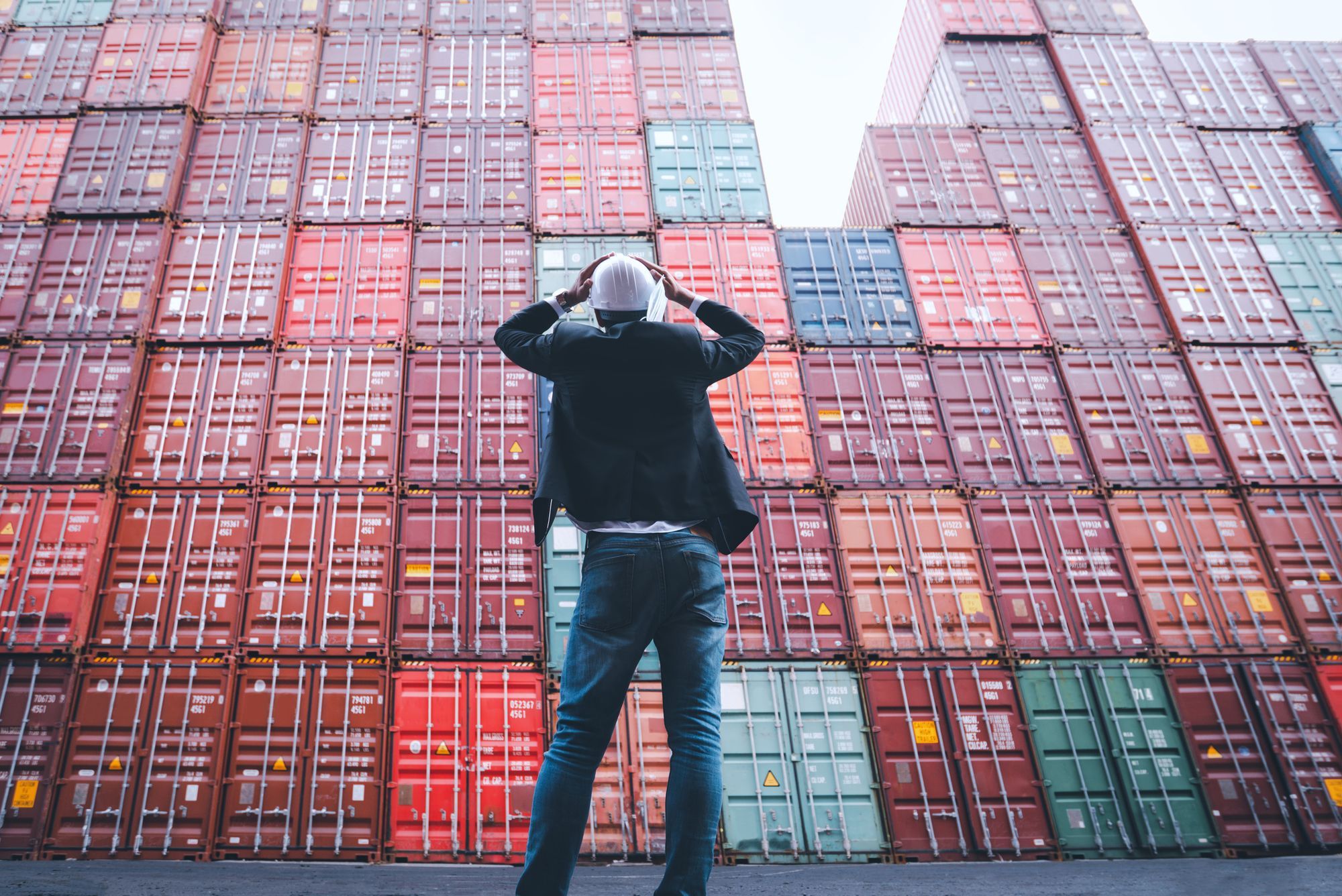 A frustrated inventory manager looking at the stacked containers