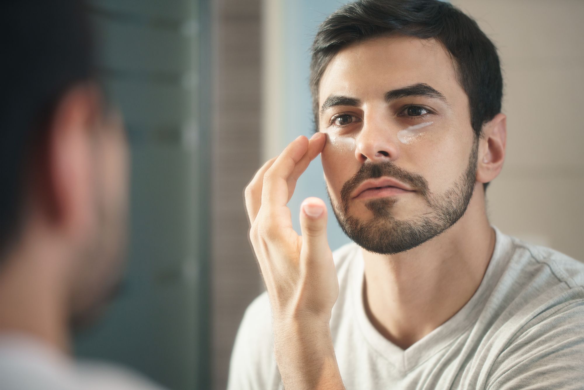 A young man who applies anti-aging cream for his own skincare routine