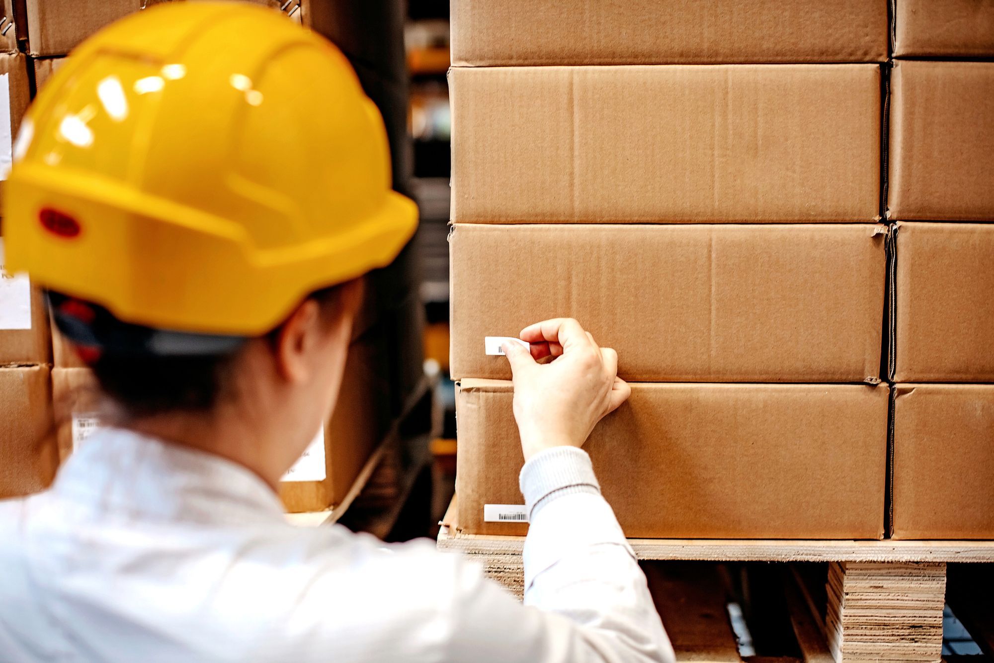 A worker affixing barcode labels to boxes