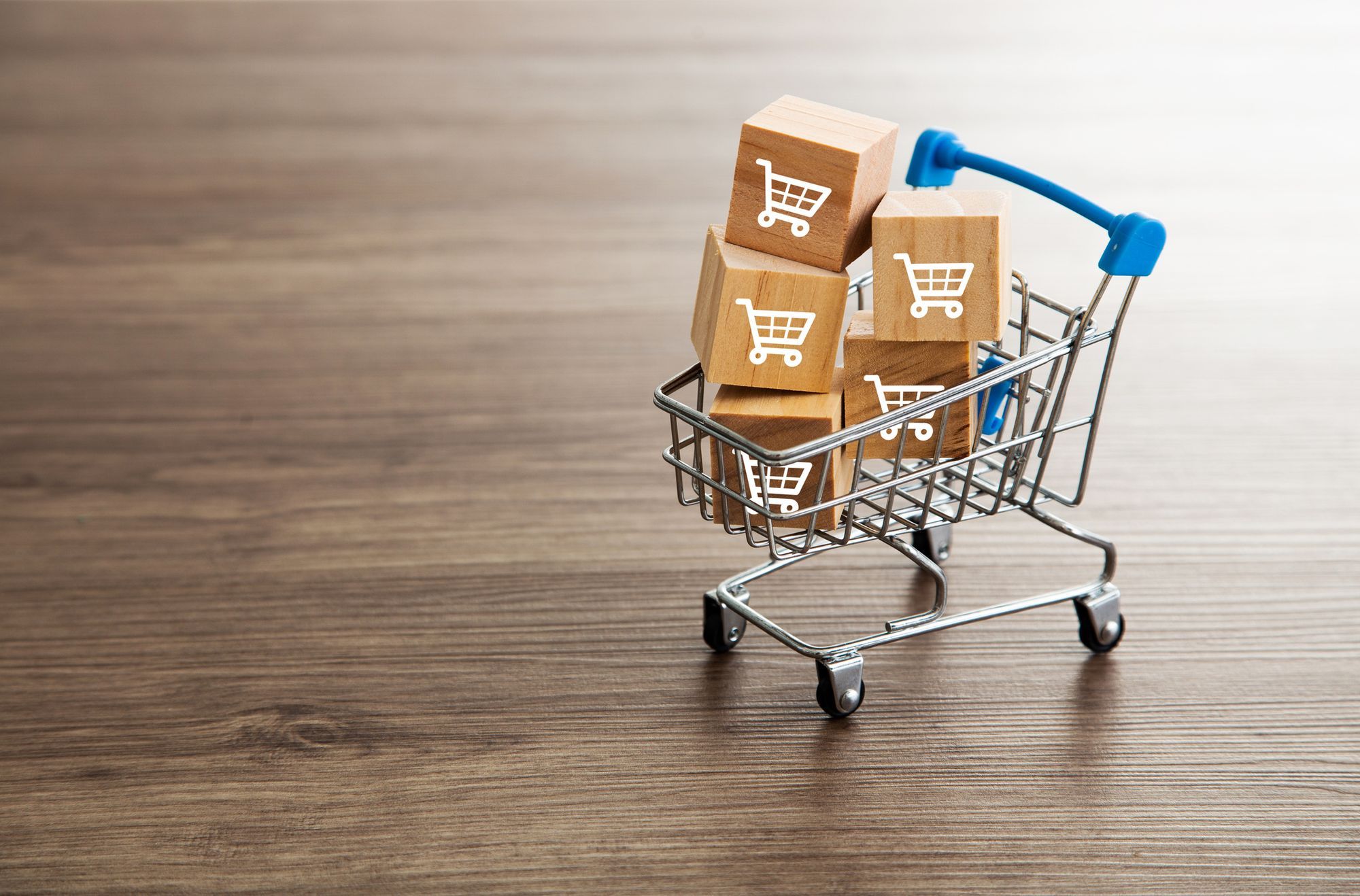 A miniature shopping cart filled with boxes of products. 