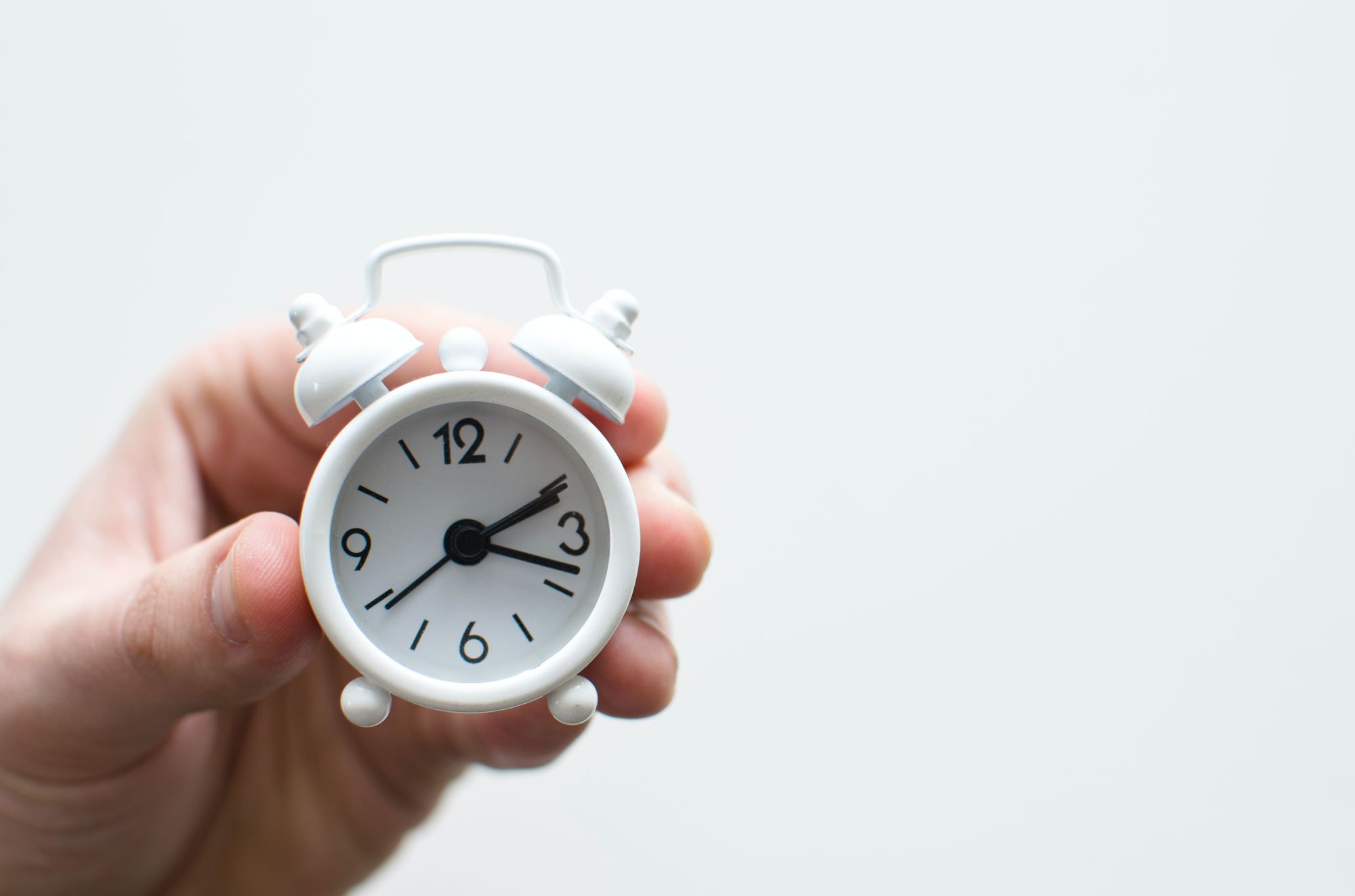 A small and white alarm clock.