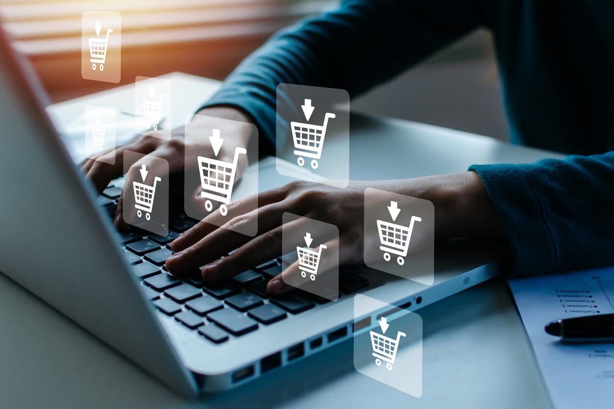 A woman's hand online shopping on laptop computer with virtual shopping carts