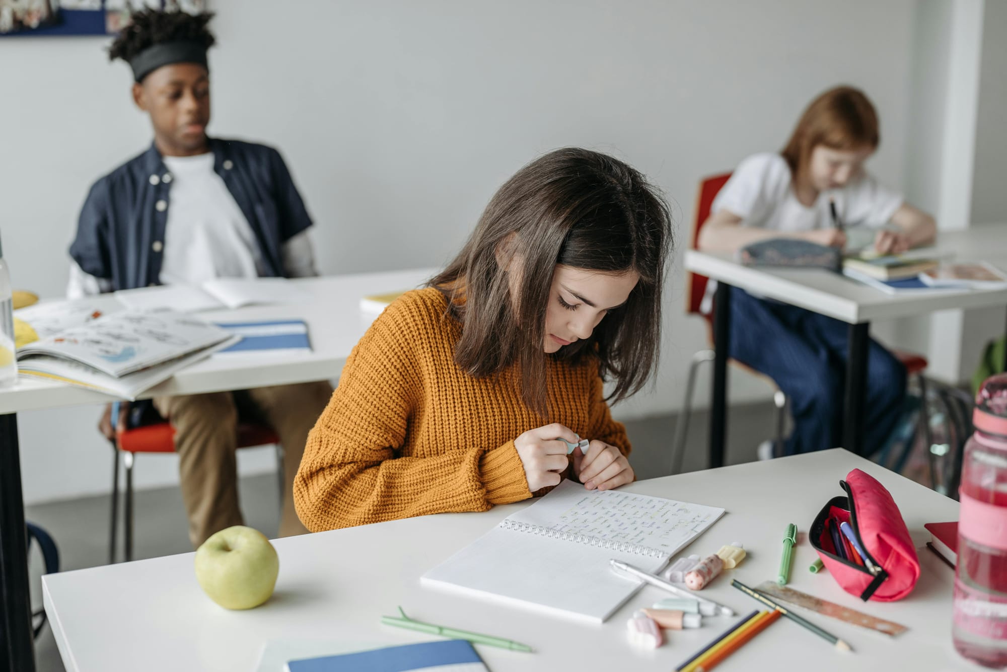 A young female student working on assignment in the classroom 