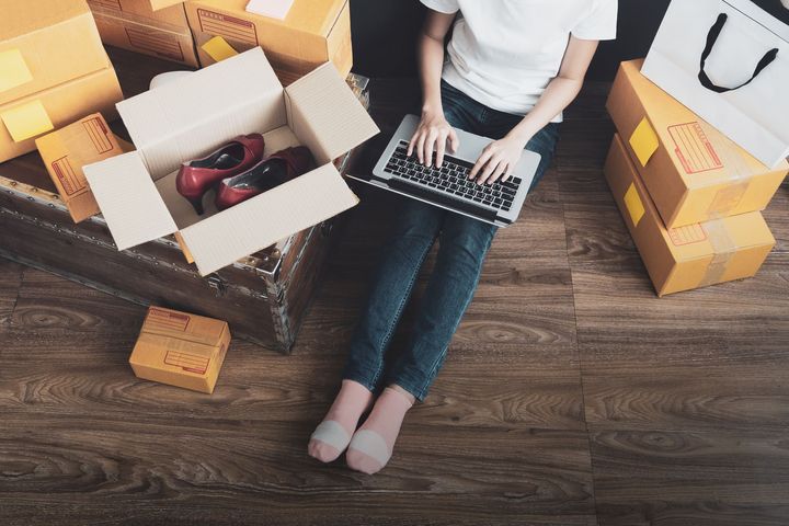 A toursau view of a female seller who is using laptop to process orders online 