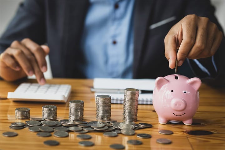 Businessman counting coins and banknotes by taking notes profit from doing business.