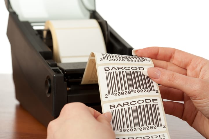 Barcode label printer with the labels ribbon, close-up on white background