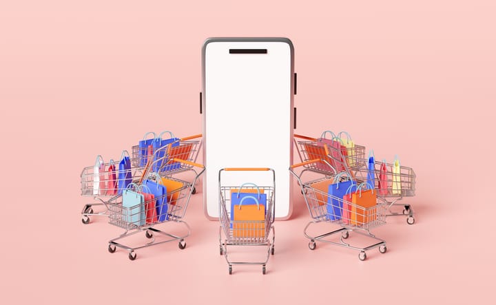 Smartphone surrounded by carts full of shopping bags to show online shopping of bundled packages