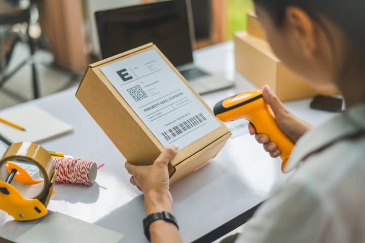 A worker scanning a package barcode with a handheld scanner 